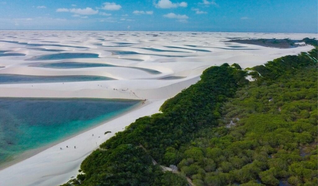 Panorama dall’alto delle dune e lagune del Parco nazionale dei Lençóis Maranhenses in Brasile, con gruppi di visitatori che camminano lungo la sabbia